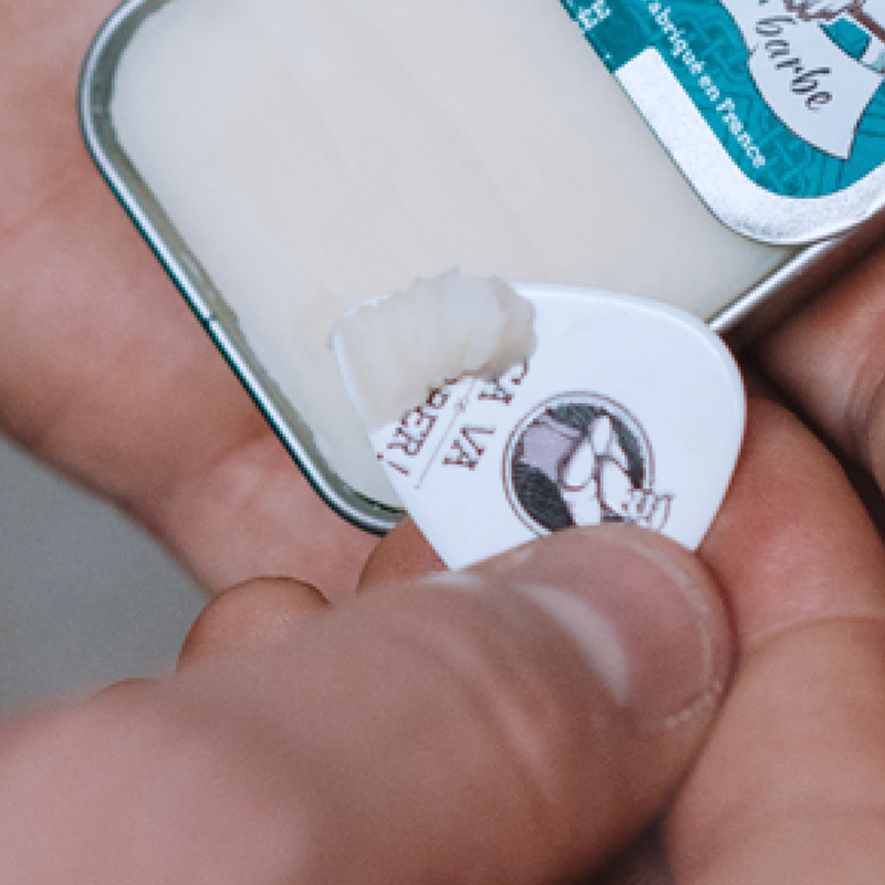 Prélèvement d'une noisette de baume pour barbe sans parfum dans sa boîte en métal Prélèvement d'une noisette de baume pour barbe sans parfum dans sa boîte en métal